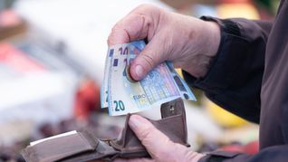 Eine Person sortiert auf einem Wochenmarkt das Wechselgeld für ihre Einkäufe in ein Portemonnaie.(Symbolfoto)